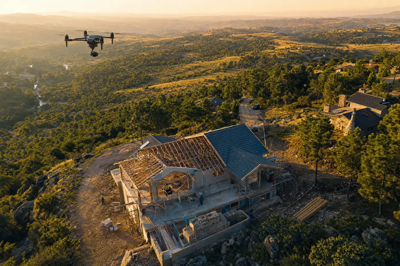 Ilustración generada con IA: vista aérea de una casa en construcción en una ladera serrana, con la estructura de madera del techo a la vista, andamios y materiales, y un drone en el aire.